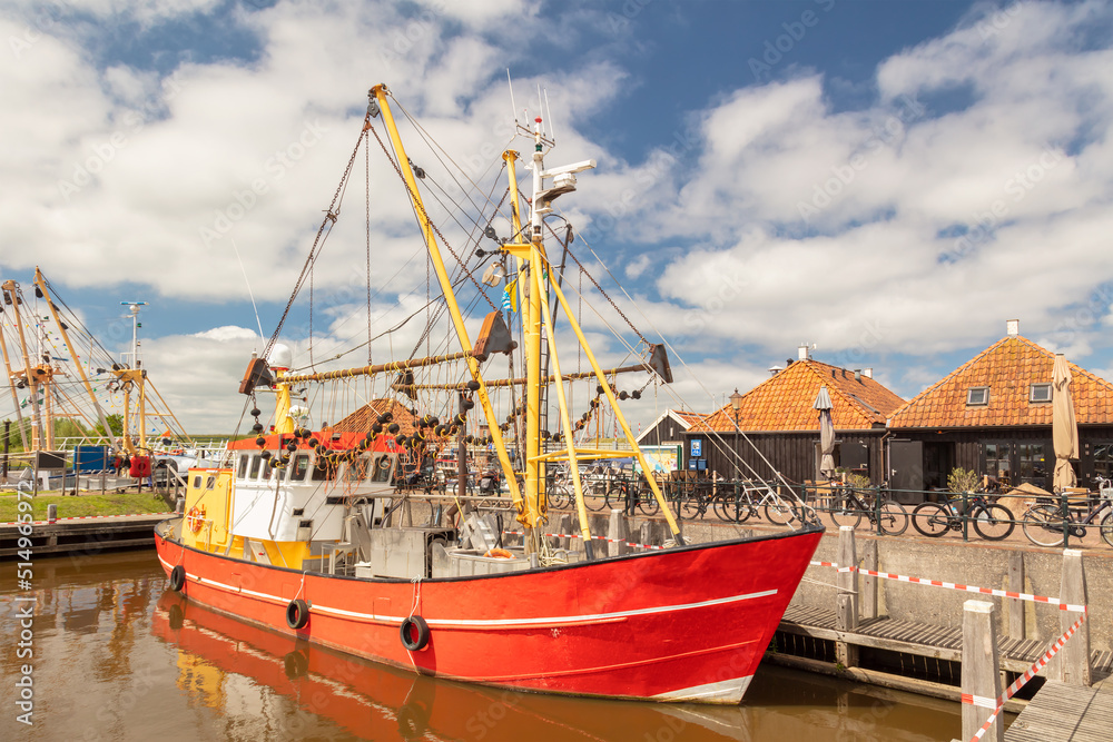 Summer view of the harbor with fishing ship and historic buildings in Zoutkamp, Groningen, The Netherlands