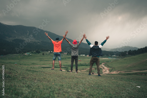 Happy friends having fun at sunset time in mountains range backdrop in Gulmarg located in the states of Jammu and Kashmir, India. photo