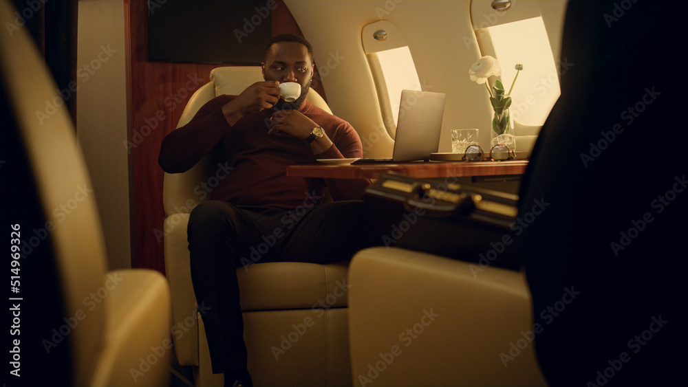 Fototapeta premium Successful businessman browse online at airplane window. Ceo on business travel