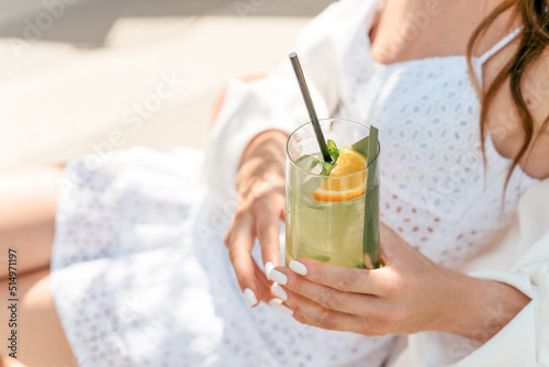 Female drinking iced mojito cocktail in the city