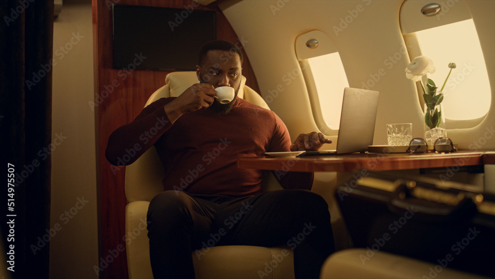 Successful man working laptop computer on business trip. African american ceo