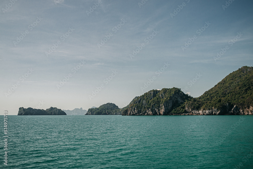 Don Sak, Nakhon Si Tammarat, Thailand - December 23rd, 2019 : views from a boat of the sea shore in Donsak, Nakhon SI Tammarat on a sunny day with limestone cliffs in the background