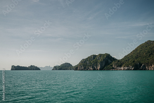 Don Sak, Nakhon Si Tammarat, Thailand - December 23rd, 2019 : views from a boat of the sea shore in Donsak, Nakhon SI Tammarat on a sunny day with limestone cliffs in the background