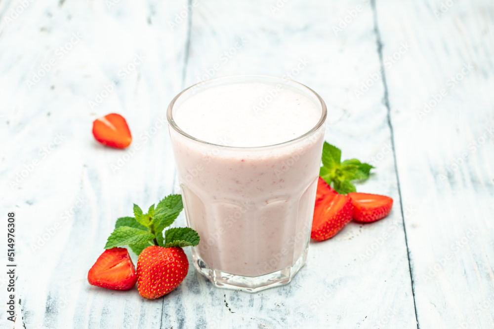 Strawberry smoothie or milkshake with berries and yogurt in glass jar on white concrete background. Vegetarian healthy drink. place for text, top view Strawberry smoothie or milkshake with berries and yogurt in glass jar on white concrete background. Vegetarian healthy drink. place for text, top view