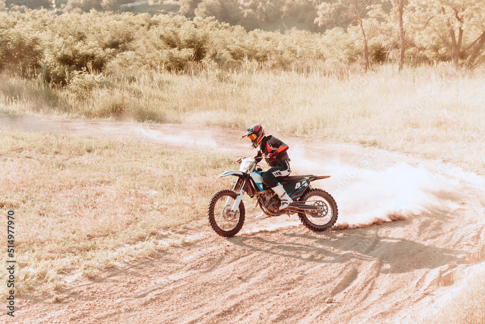 Fototapeta premium Live shot of male sportsman training on motorbike at hot summer day, outdoors. Motocross rider in action. Motocross sport