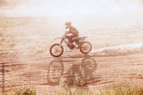 Live shot of male sportsman training on motorbike at hot summer day  outdoors. Motocross rider in action. Motocross sport