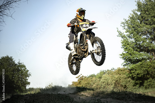 Live shot of male sportsman training on motorbike at hot summer day  outdoors. Motocross rider in action. Motocross sport