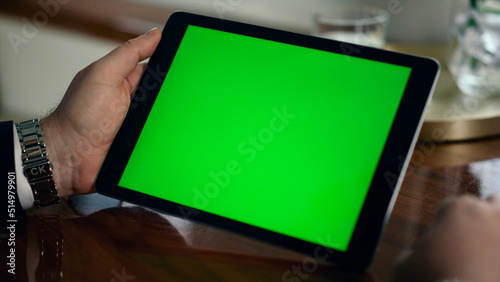 Closeup mockup tablet computer in man hands. Businessman hold green screen pad