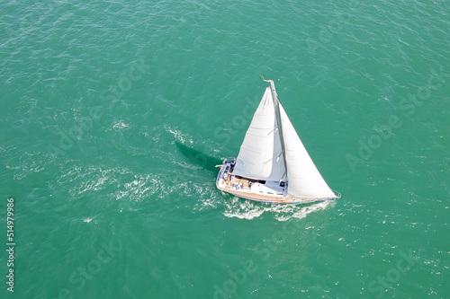 Aerial view of sailing yacht with white sail