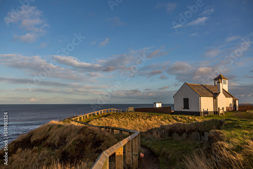 Tableau sur toile The old Watch House on the cliffs above Seaton Sluice in Northumberland, England at sunset