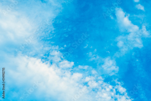 Background with white clouds on blue sky. Pattern on the theme of nature, tranquility and serenity.
