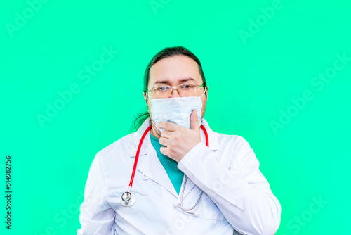 A doctor in a white coat and a mask holds his chin thoughtfully. Medical problems and their solution.