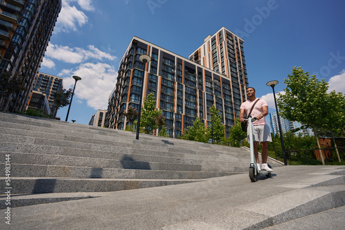 Male getting around city center by e-scooter