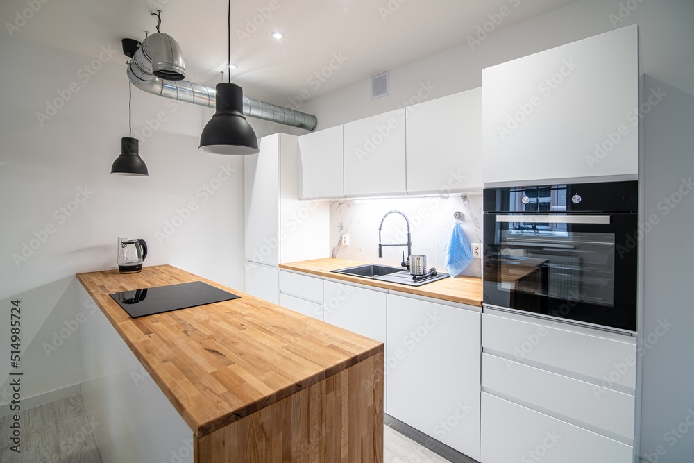 Fototapeta premium Modern kitchen with a dining area and a counter. White and wooden furniture