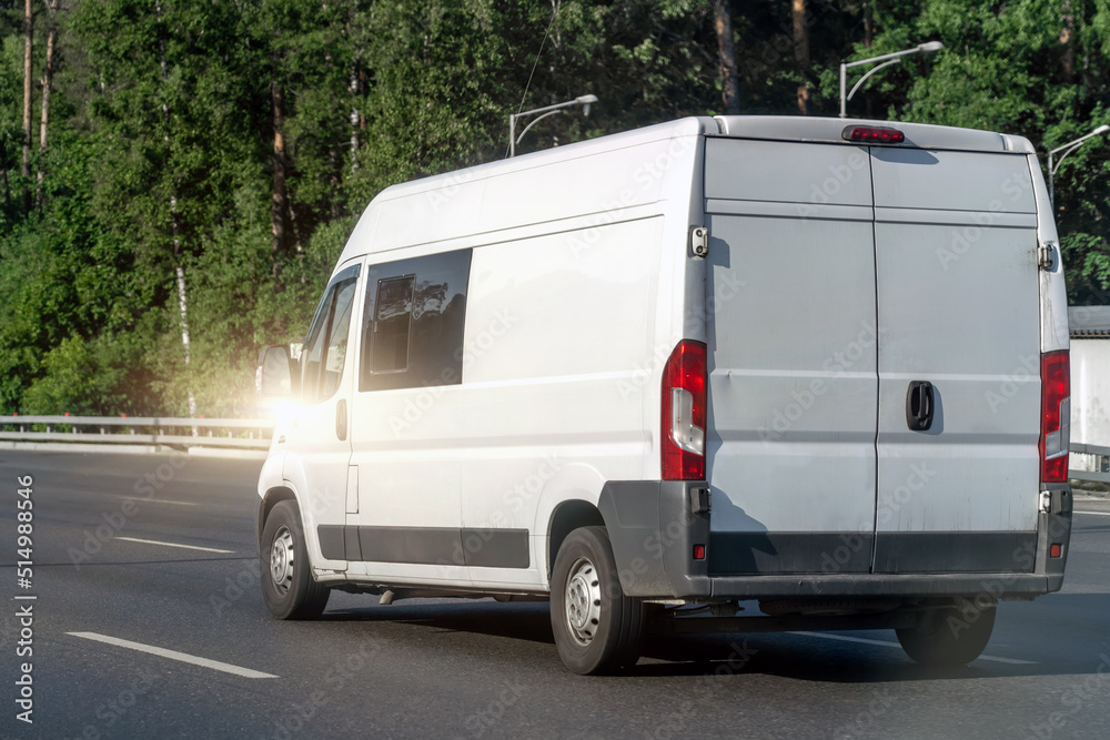 Naklejka premium Blank white delivery van truck on highway outdoors