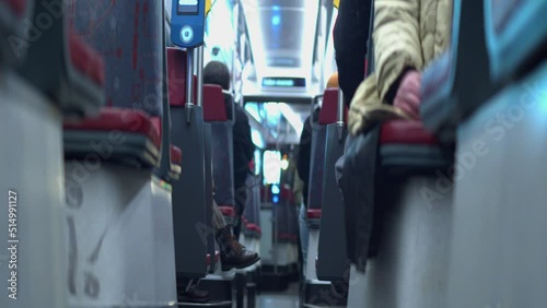 Narrow focus low angle POV: Passengers on metro train commute at night photo