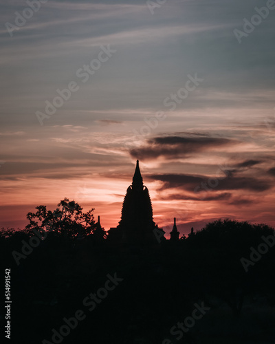 Vertical view of a sunset on a temple ruin in old Bagan, Myanmar with clouds in the colorful sky © LeaGuPhoto