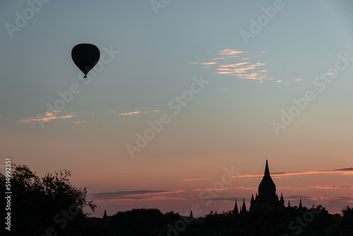 Bagan, Myanmar : view on a Buddhist temple in the ancient city of Bagan, Myanmar at sunrise with a hot air balloon in the sky