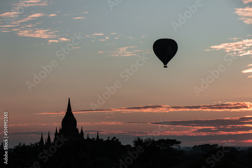 Bagan, Myanmar : view on a Buddhist temple in the ancient city of Bagan, Myanmar at sunrise with a hot air balloon in the sky