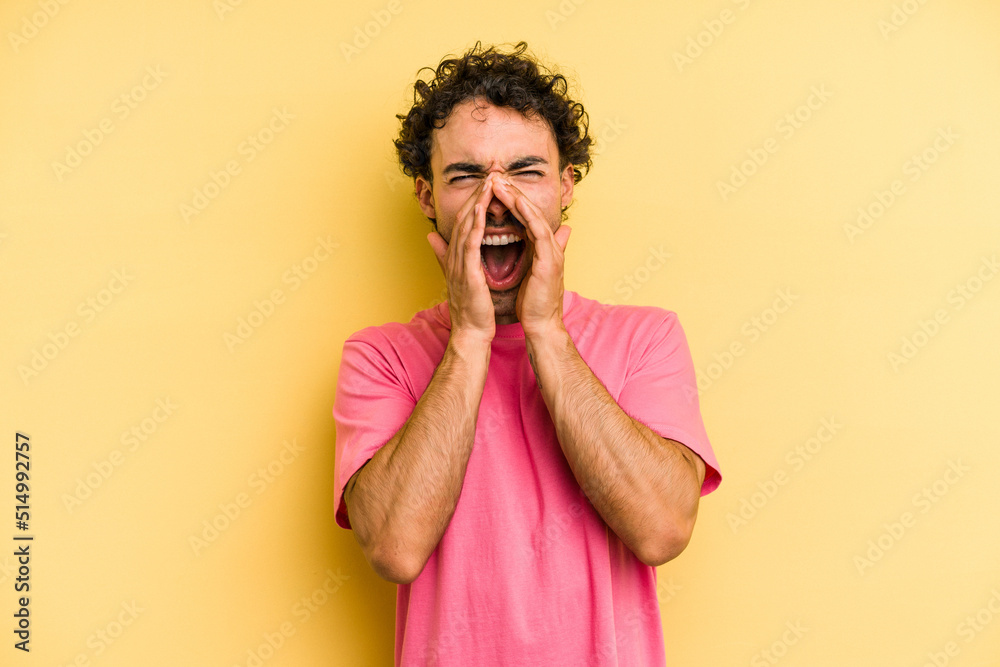 Young caucasian man isolated on yellow background shouting excited to front. Young caucasian man isolated on yellow background shouting excited to front.