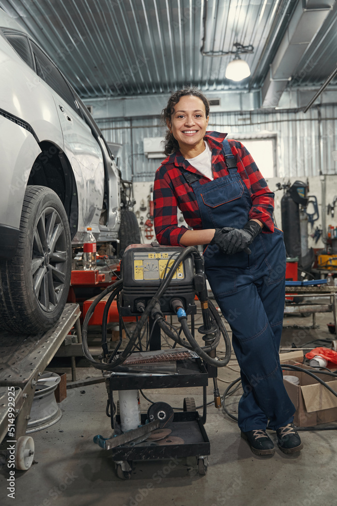 Happy car mechanic posing on camera in garage Happy car mechanic posing on camera in garage