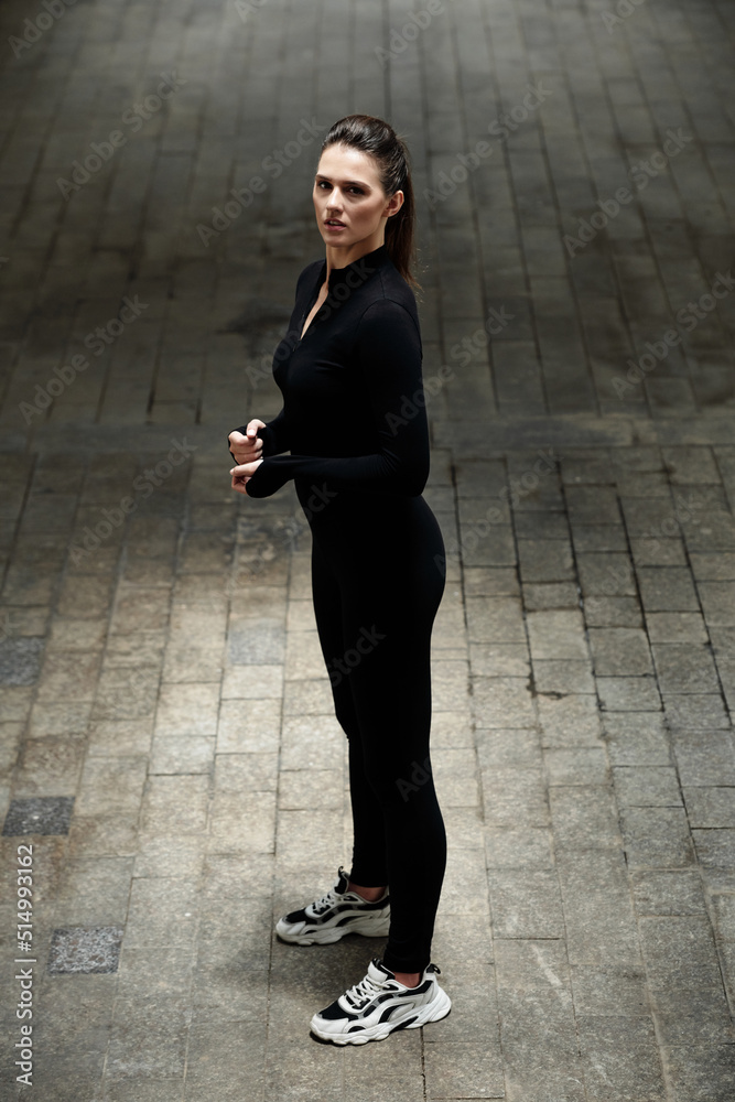 Portrait of slim dancer girl in black clothing dancing in contemporary style outdoors
