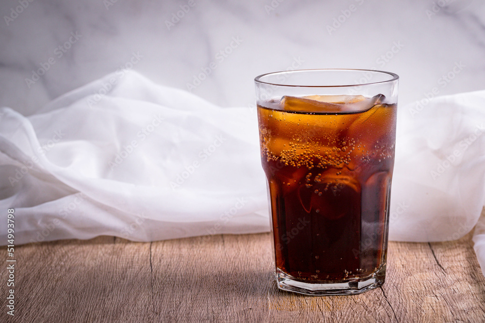 cola cola drink with ice in glass put on wooden background