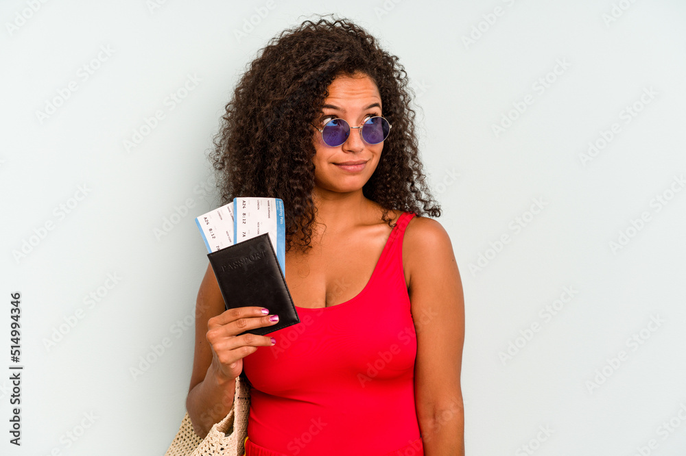 Naklejka premium Young brazilian woman wearing a swimsuit isolated on blue background dreaming of achieving goals and purposes