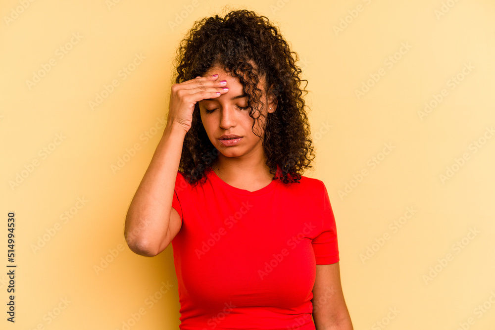 Young Brazilian woman isolated on yellow background having a head ache, touching front of the face. Young Brazilian woman isolated on yellow background having a head ache, touching front of the face.