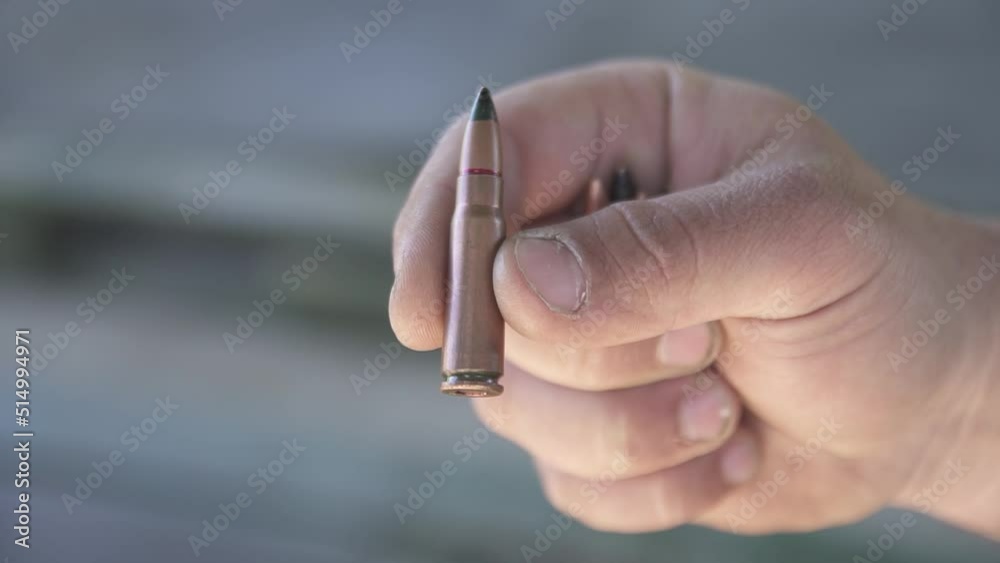 Armor-piercing cartridge 7.62x39 mm close-up holden in fingers Armor-piercing cartridge 7.62x39 mm close-up holden in fingers