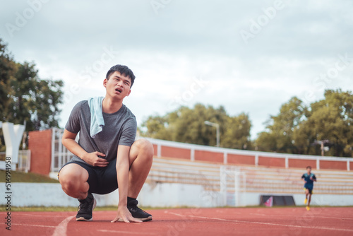 Exhausted man resting after jogging in the stadium during day.