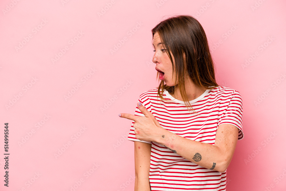 Young caucasian pregnant woman isolated on white background points with thumb finger away, laughing and carefree.