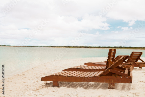 Deckchair lounger on the edge of the beach in summer with nice tropical weather. Resort by the sea in Brazil. Beach chair concept. Tourism concept. Copy space.