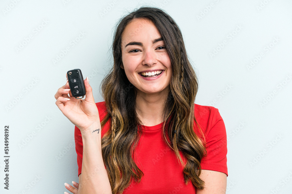 Young caucasian woman holding car keys isolated on blue background laughing and having fun. Young caucasian woman holding car keys isolated on blue background laughing and having fun.