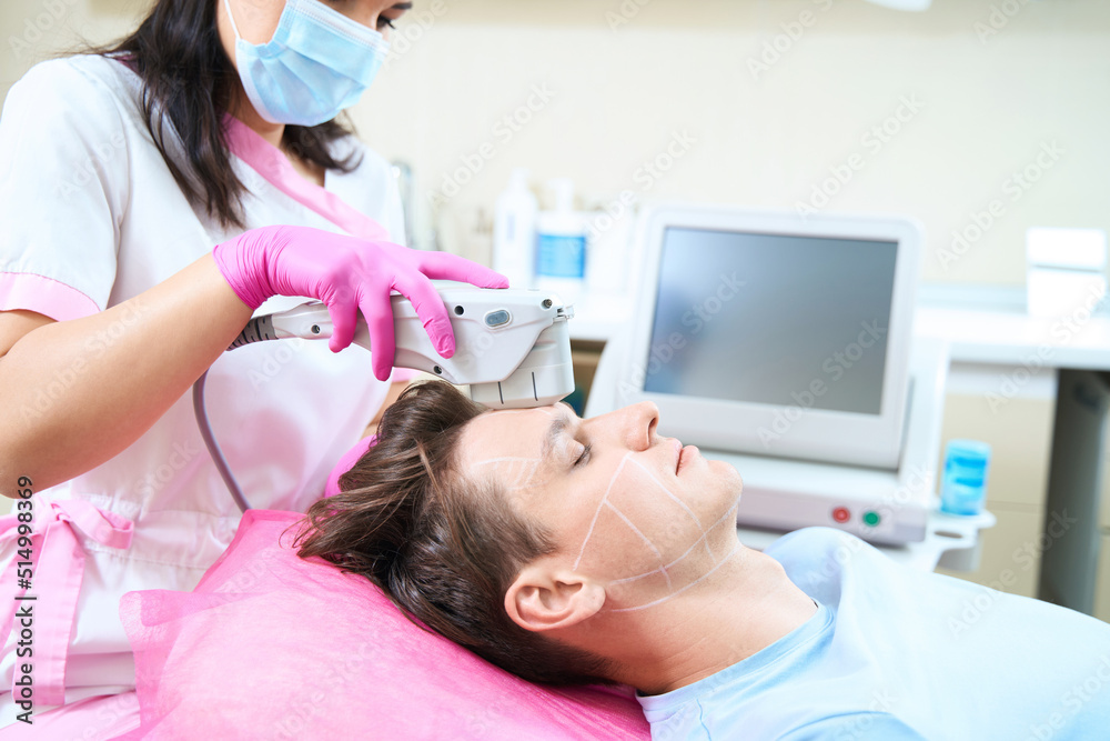 Young man during smas lifting procedure with cosmetologist Young man during smas lifting procedure with cosmetologist