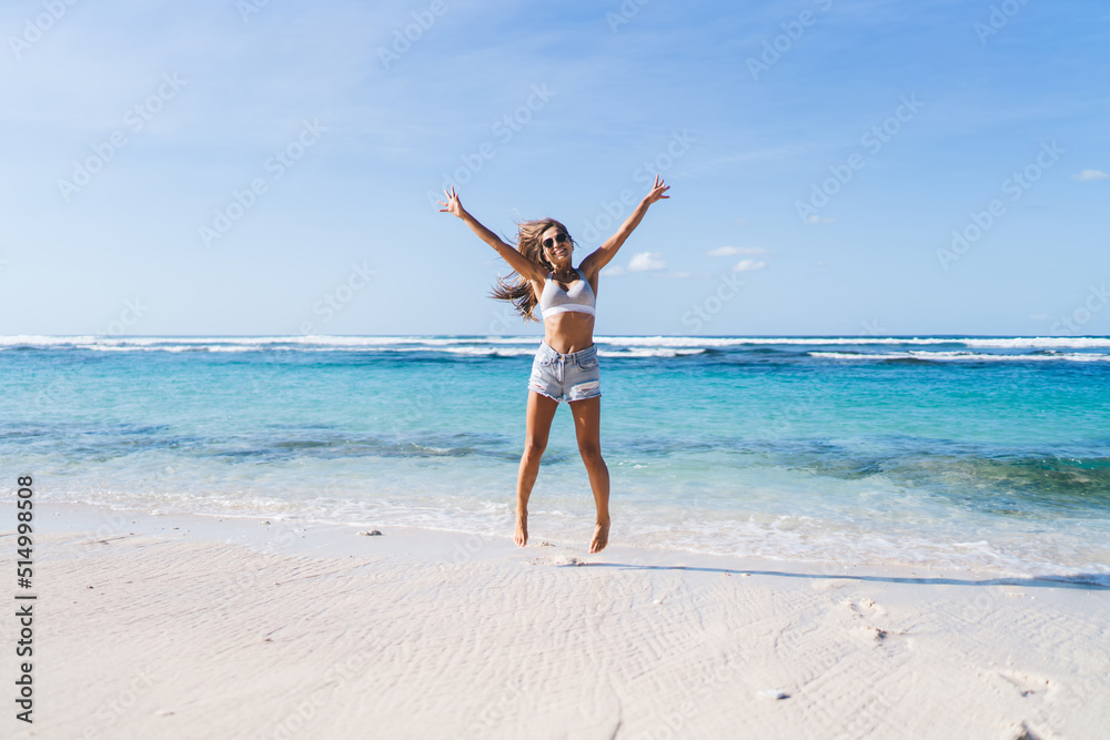 Carefree female jumping at seashore beach - enjoying summer freedom on getaway vacations for recreating, happy Caucaisan tourist feeling delight and rejoices - visiting Sri Lanka during sunny season Carefree female jumping at seashore beach - enjoying summer freedom on getaway vacations for recreating, happy Caucaisan tourist feeling delight and rejoices - visiting Sri Lanka during sunny season