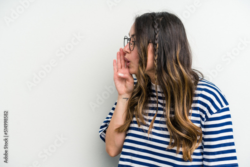 Young caucasian woman isolated on white background is saying a secret hot braking news and looking aside