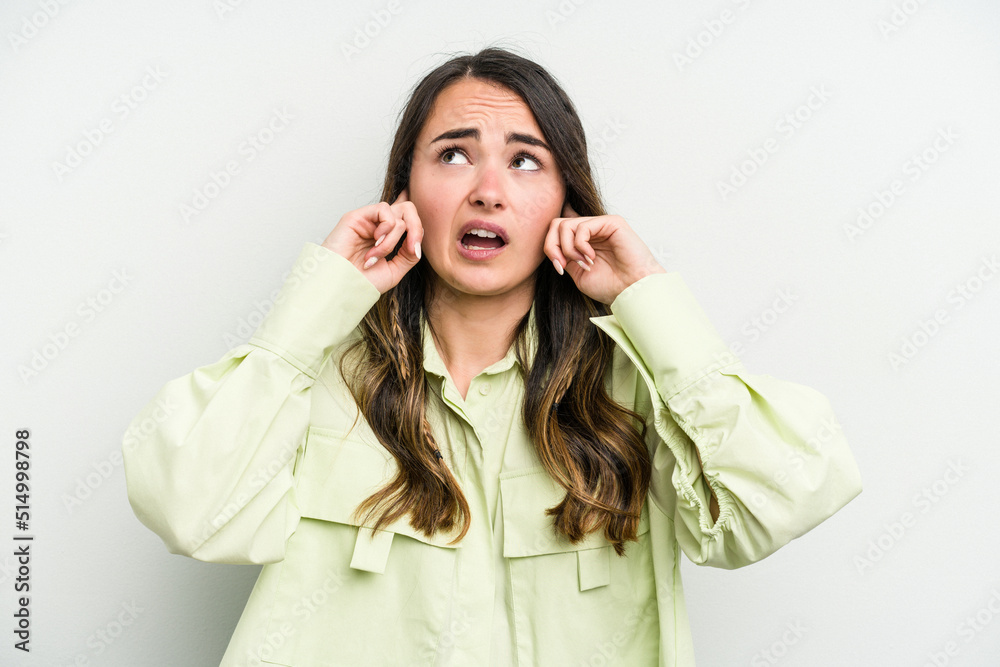 Young caucasian woman isolated on white background covering ears with fingers, stressed and desperate by a loudly ambient. Young caucasian woman isolated on white background covering ears with fingers, stressed and desperate by a loudly ambient.