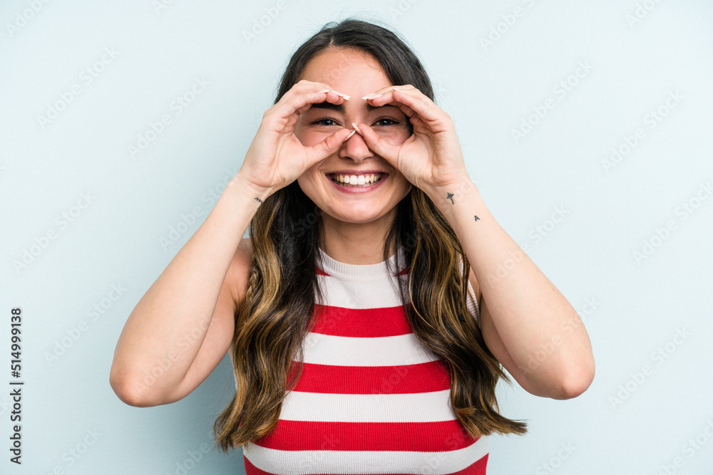 Young caucasian woman isolated on blue background showing okay sign over eyes Young caucasian woman isolated on blue background showing okay sign over eyes