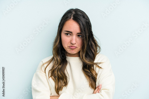 Young caucasian woman isolated on blue background tired of a repetitive task.