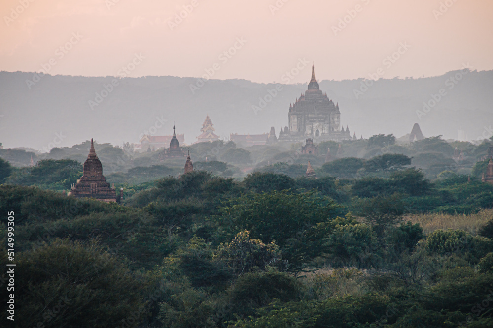 Panoramic view on temple ruins in the ancient archeological city of Bagan, Myanmar at sunrise with a foggy sky