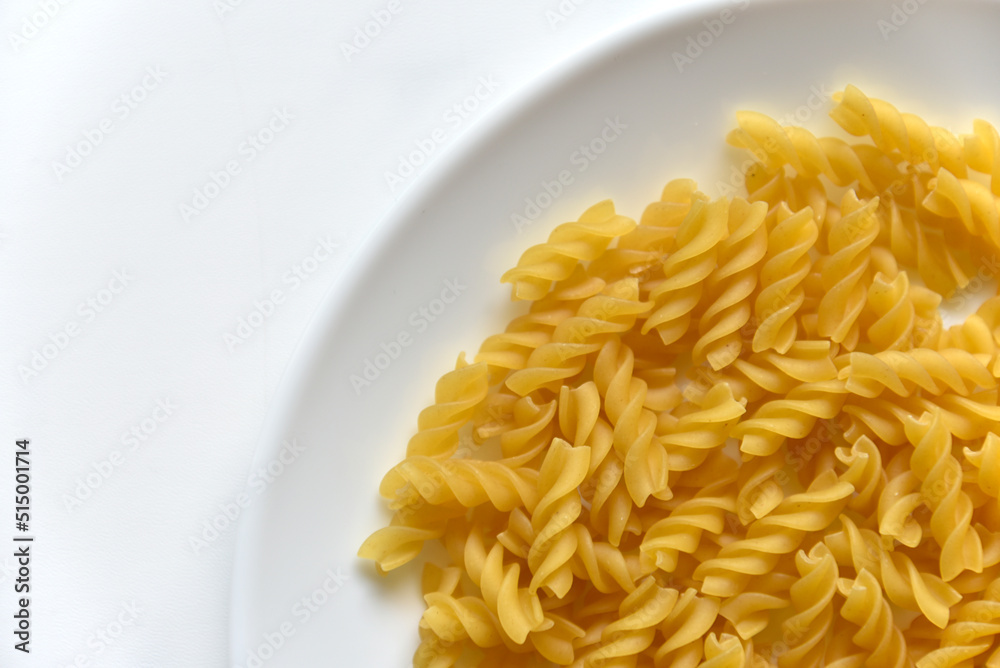Yellow twisted raw pasta on a white plate Yellow twisted raw pasta on a white plate