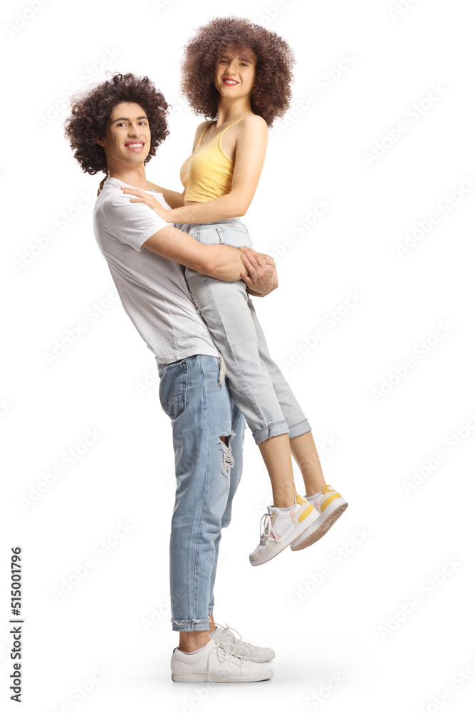 Full length side shot of a guy with curly hair lifting a girl Full length side shot of a guy with curly hair lifting a girl