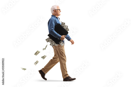 Full length profile shot of a mature man walking with a briefcase full of money
