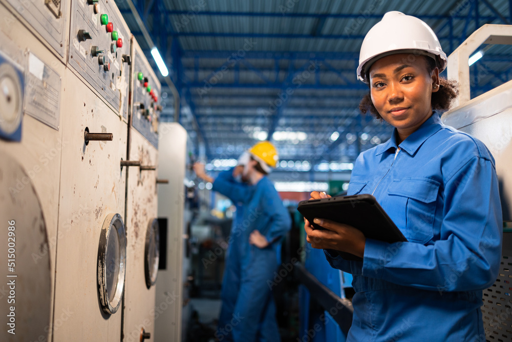 African American Young woman worker in protective uniform operating machine at factory Industrial.People working in industry.Portrait of Female Engineer at work place. African American Young woman worker in protective uniform operating machine at factory Industrial.People working in industry.Portrait of Female Engineer at work place.