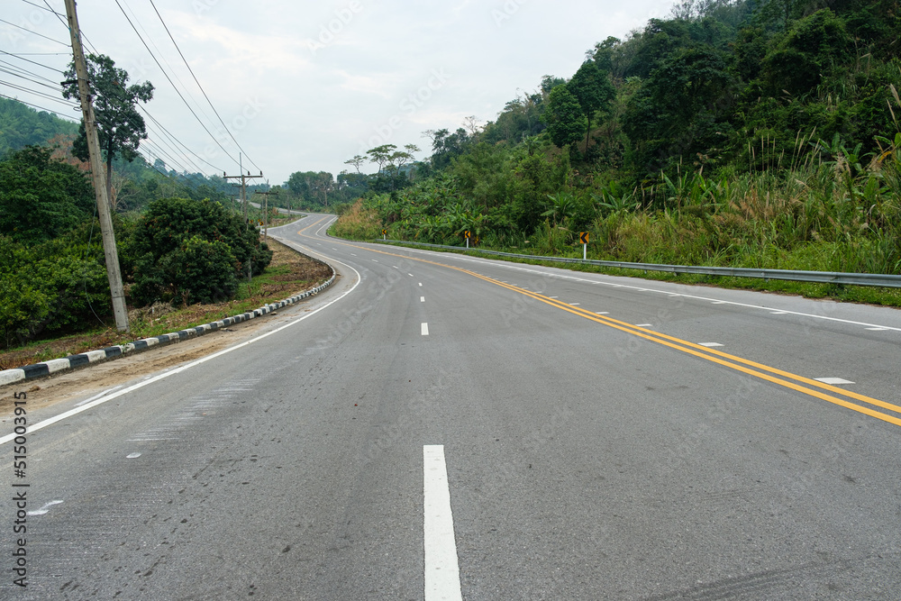 Paved road Thailand.The asphalt road on both sides of the road is covered with grass. Paved road Thailand.The asphalt road on both sides of the road is covered with grass.