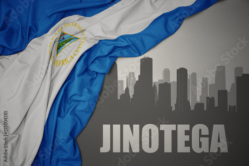 abstract silhouette of the city with text Jinotega near waving national flag of nicaragua on a gray background. 3D illustration photo