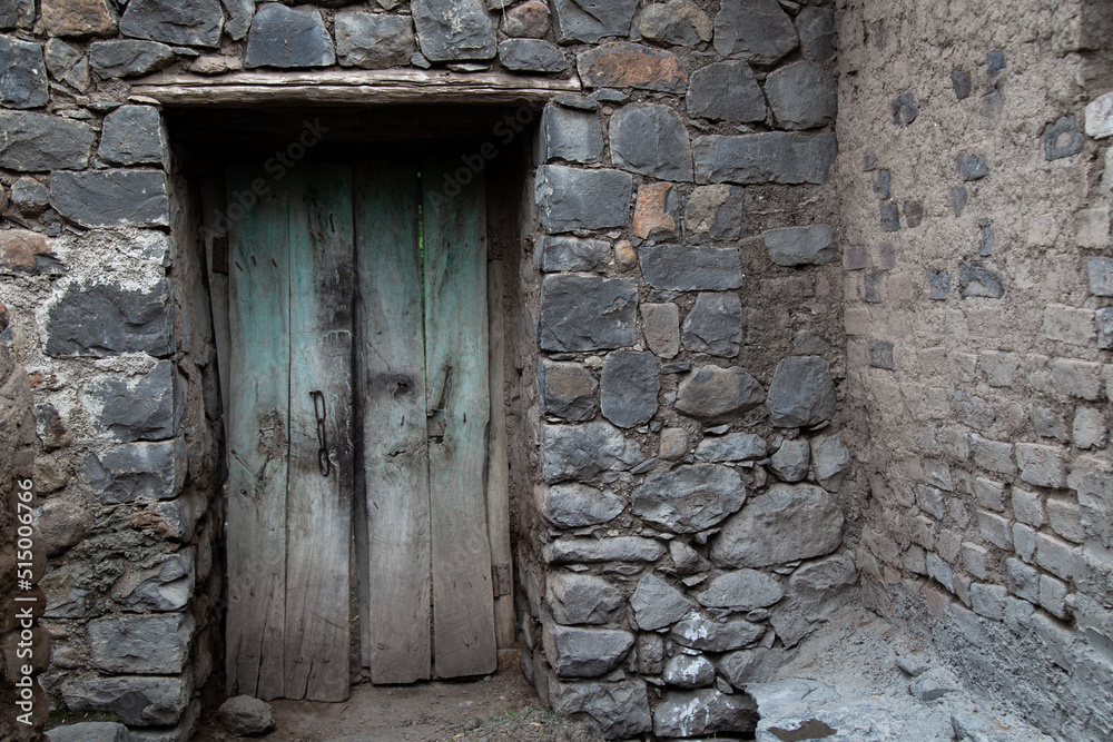 Old wooden door with black rock stone house in the village of Maharashtra, India, Generic background and pattern.