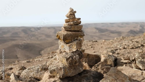 Tight focus on a conical stone cairn while revealing endless barren countryside