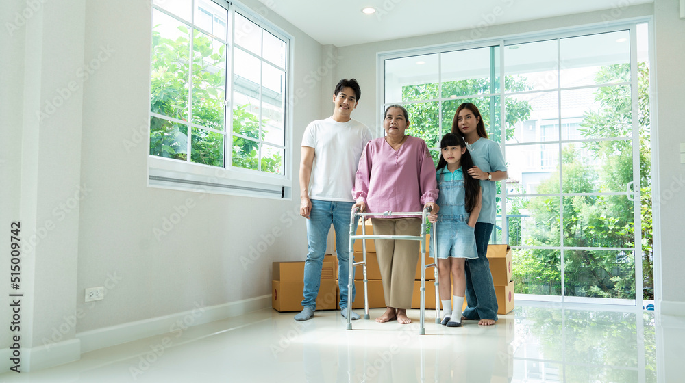 Fototapeta premium Grandma takes Walker to move into her new home with her family, her son and daughter-in-law and granddaughter are all happy to move to new home. Home loan and family relationship concept.